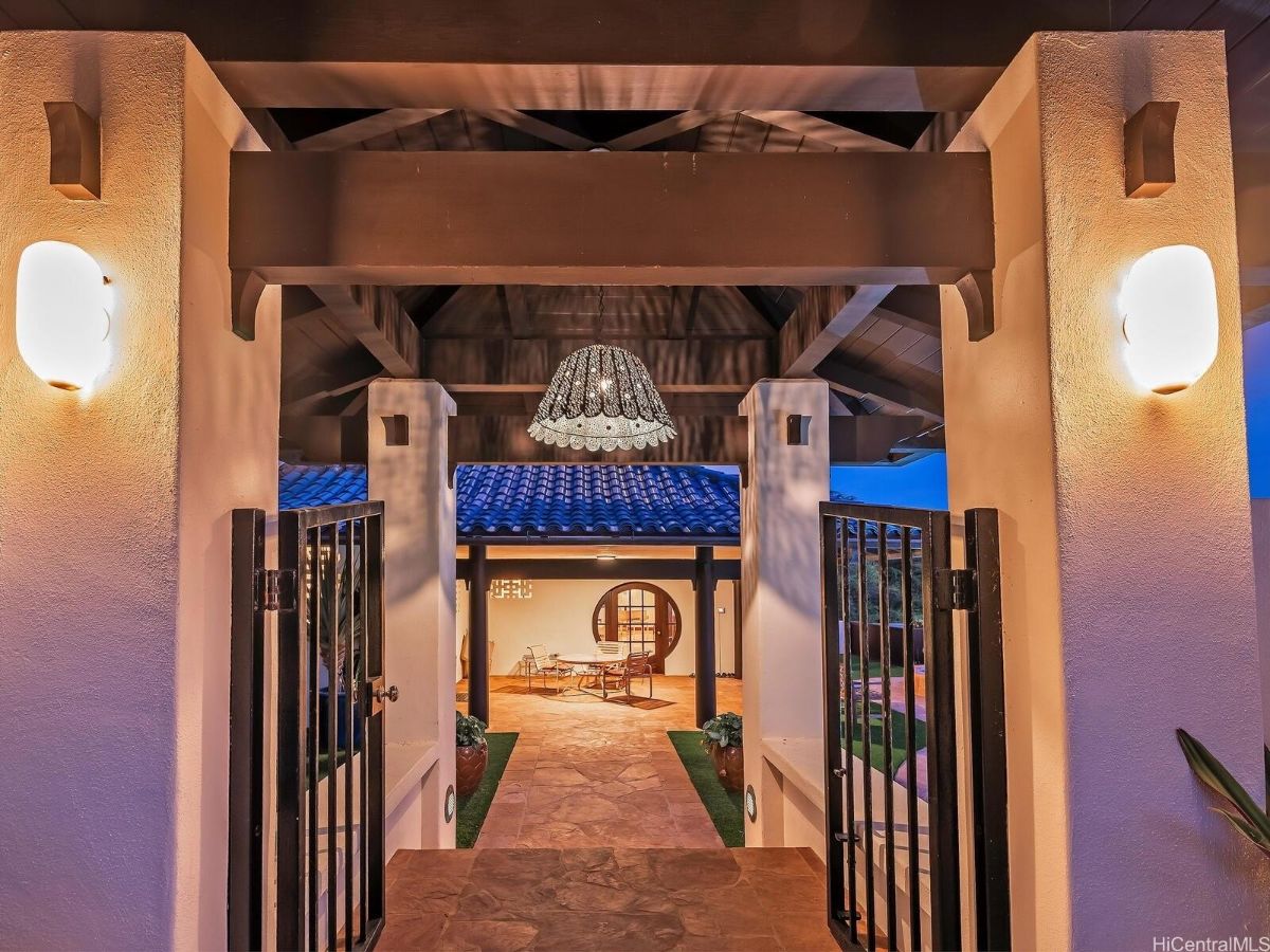 The main entrance features a metal gate and wall lights giving off a classic feel to the place.