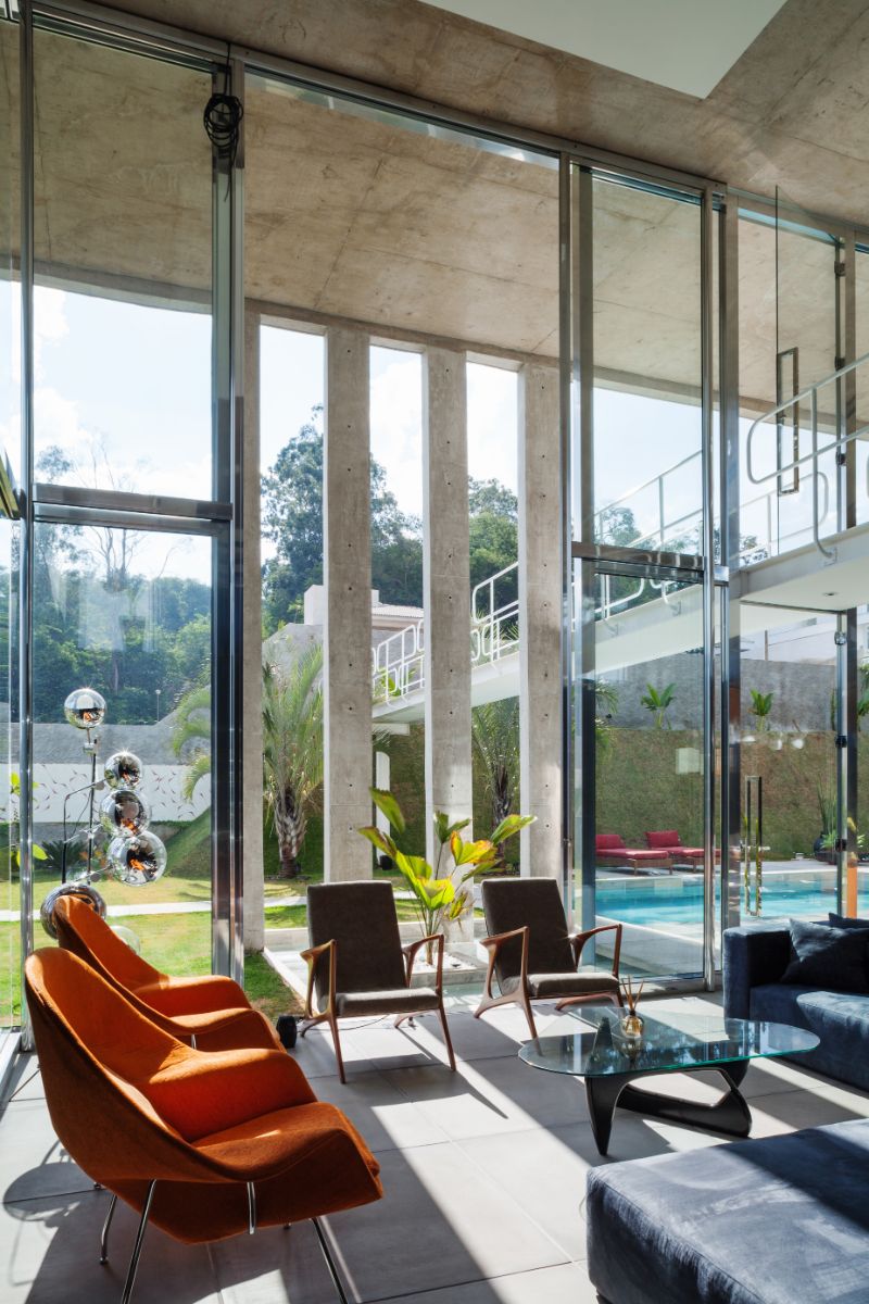 The massive glass wall floods the living room with light and provides a view of the pool and manicured landscape.