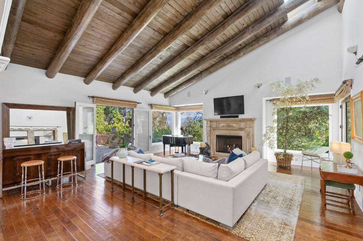 The living room features a fireplace and a sectional sofa giving off a cozy feel.