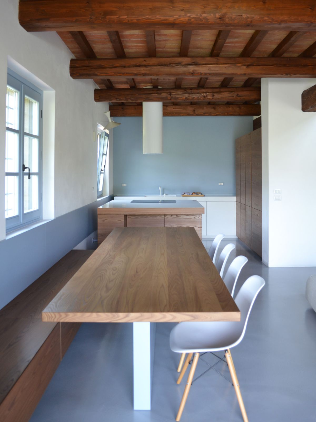 The dining room features a wooden table, and the exposed wooden ceiling gives the room a rustic feel.
