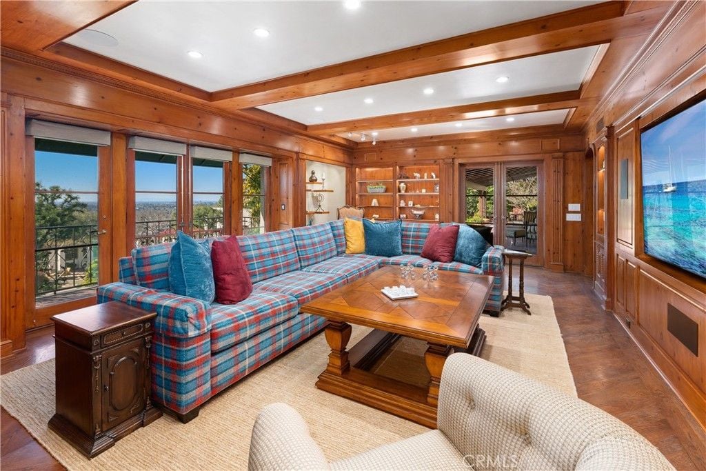 The living area features an antique table and a sectional sofa.
