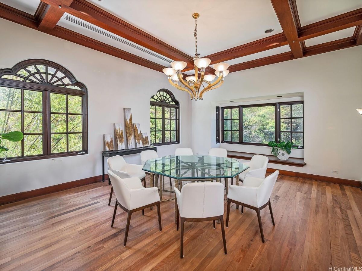 The dining room features a glass dining table, and the wooden floors give off a rustic feel.