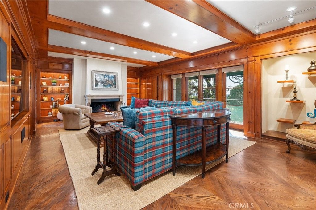The wooden flooring and the exposed ceiling give the room a rustic feel, and the living area features a fireplace that warms the room.
