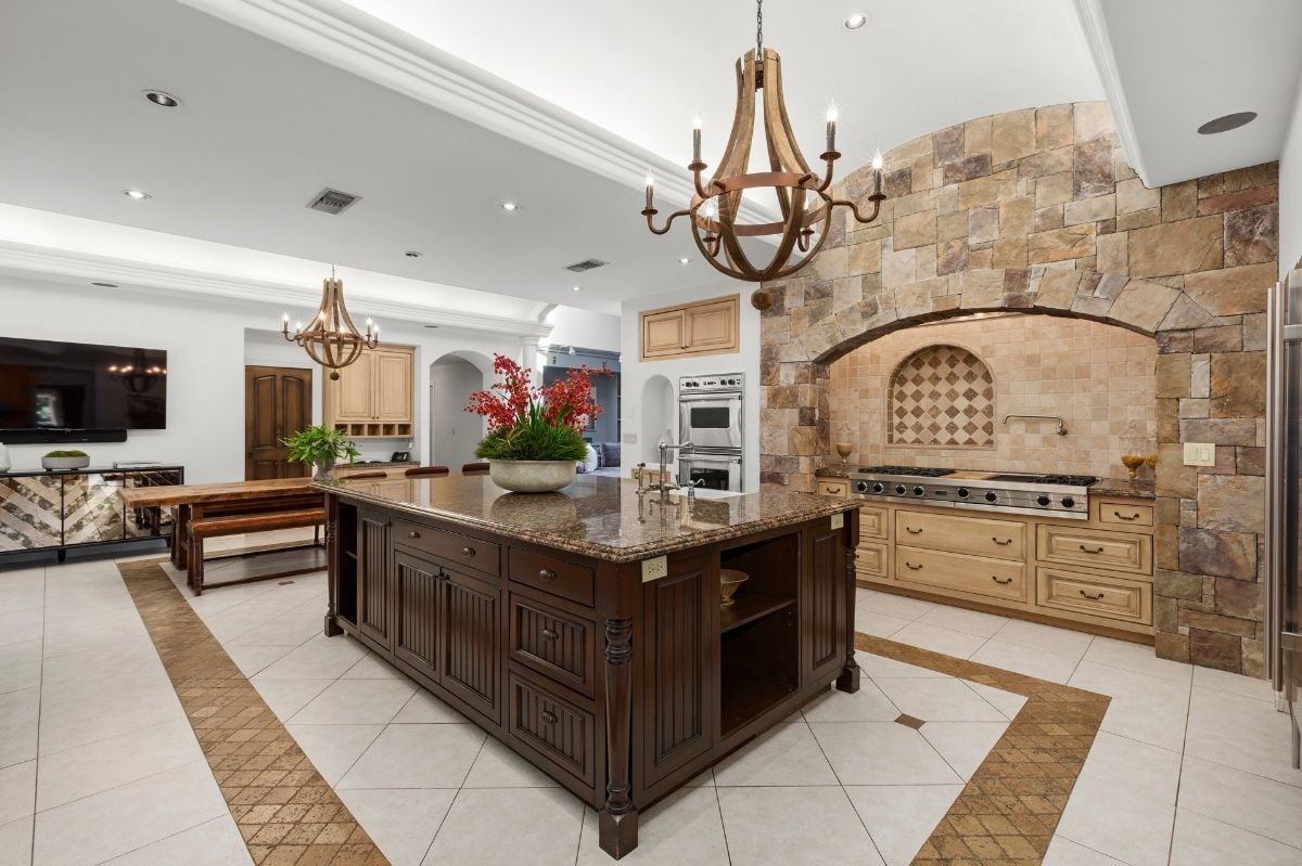 The kitchen features a kitchen island with a granite countertop, and the wood and concrete give the room a rustic feel.