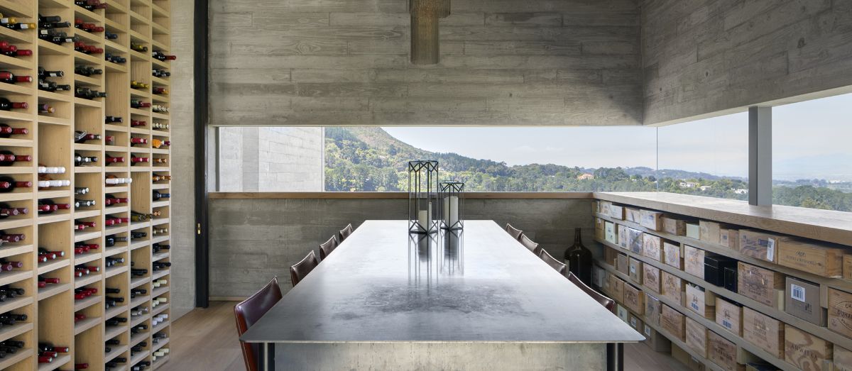 The wine room, which has a well-organized wine rack and a full-length window with a view of the landscape and mountain.