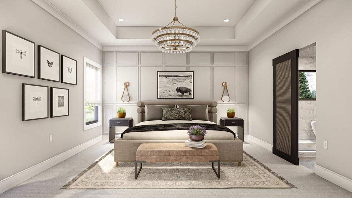 Primary bedroom with a tray ceiling, a wainscoted accent wall, and a barn door that reveals the primary bathroom.