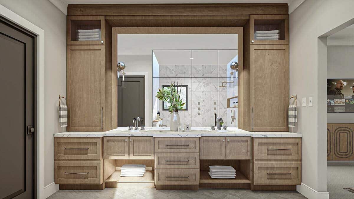 A large vanity with two sinks, wooden cabinets, and a huge mirror completes the primary bathroom.