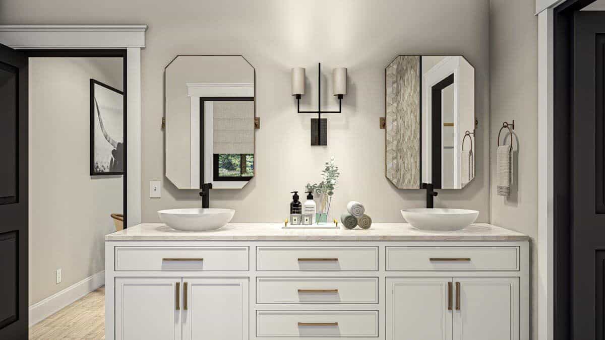 The primary vanity is equipped with two vessel sinks, a marble counter, octagonal mirrors, and white cabinets.