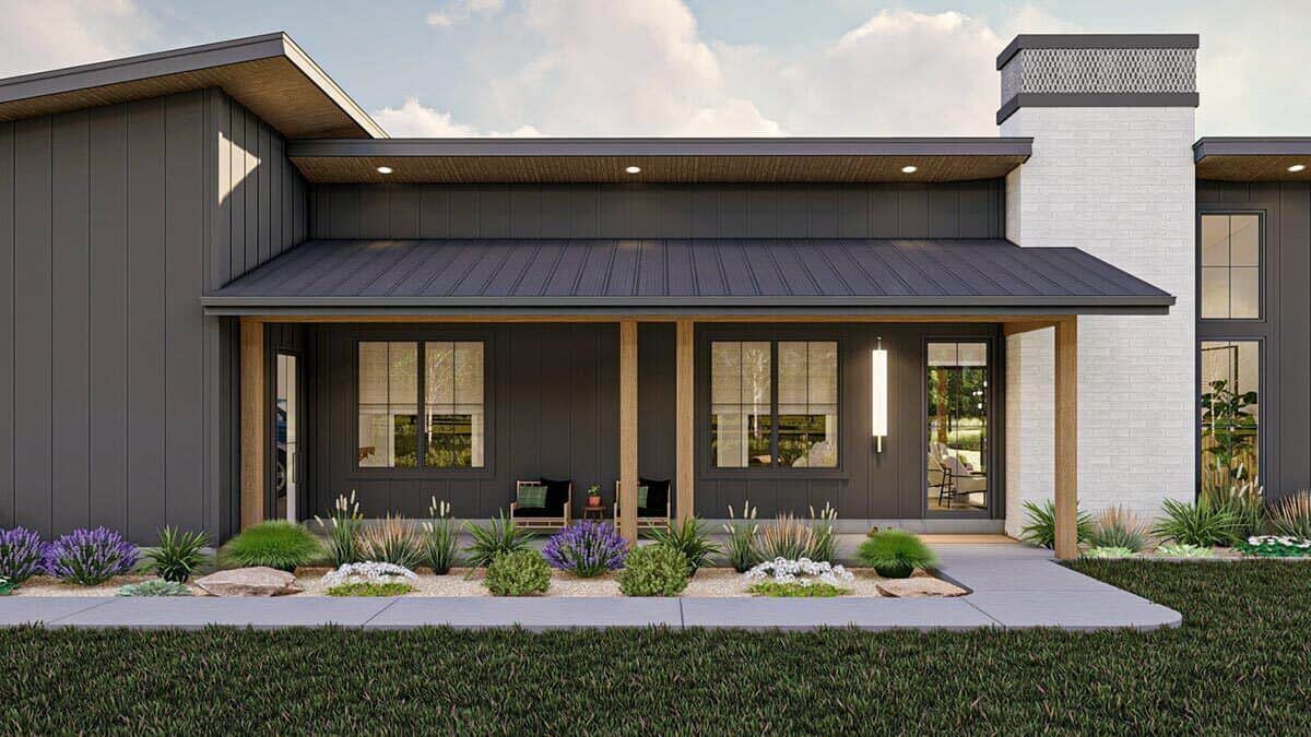 A closer look at the covered entry porch with wooden armchairs and a glazed front door.