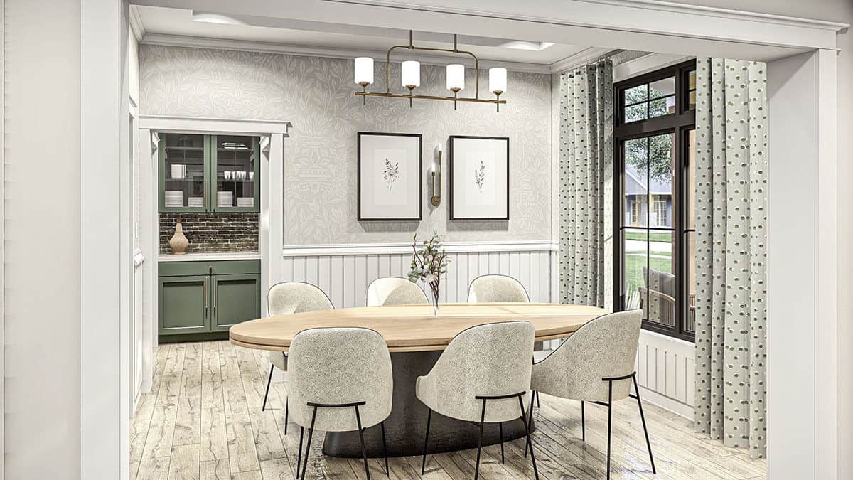 Formal dining room with half-beadboard walls and an oval dining set well-lit by a linear chandelier and large windows.