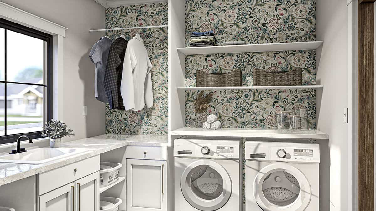 The laundry room is equipped with a front-load washer and dryer, lots of storage, and a utility sink under the framed window.