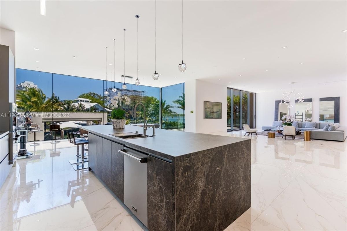 The kitchen features a bi-level kitchen island with a tile countertop overlooking the living area and the dining table.