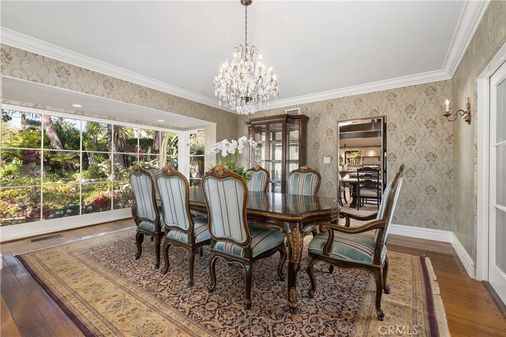 The dining room features a beautiful antique table and chandelier, giving off a luxurious feel.