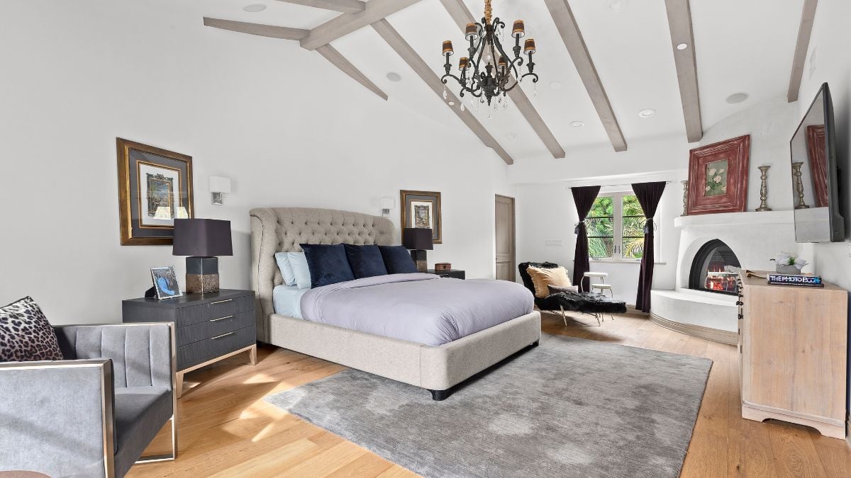 The bed, carpet, single chair, and side table are all gray in this bedroom's interior decor. The photo frames made the space look lovely.