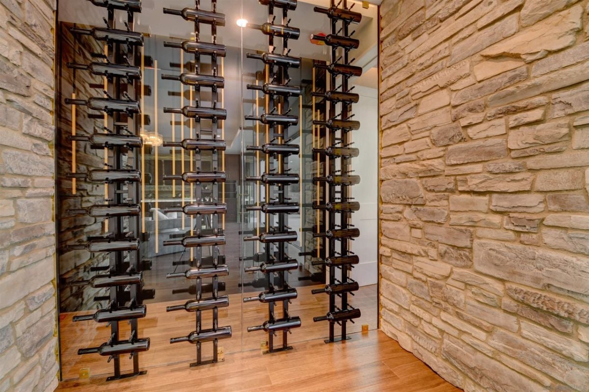 The wine cellar features a stone wall and a uniquely designed wine rack.