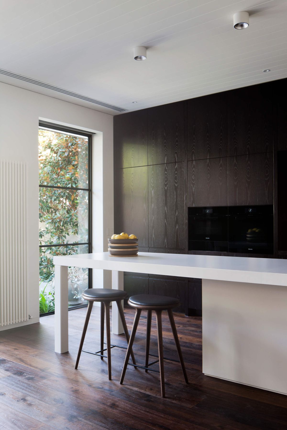 The stools are placed at the end of the kitchen island tables.