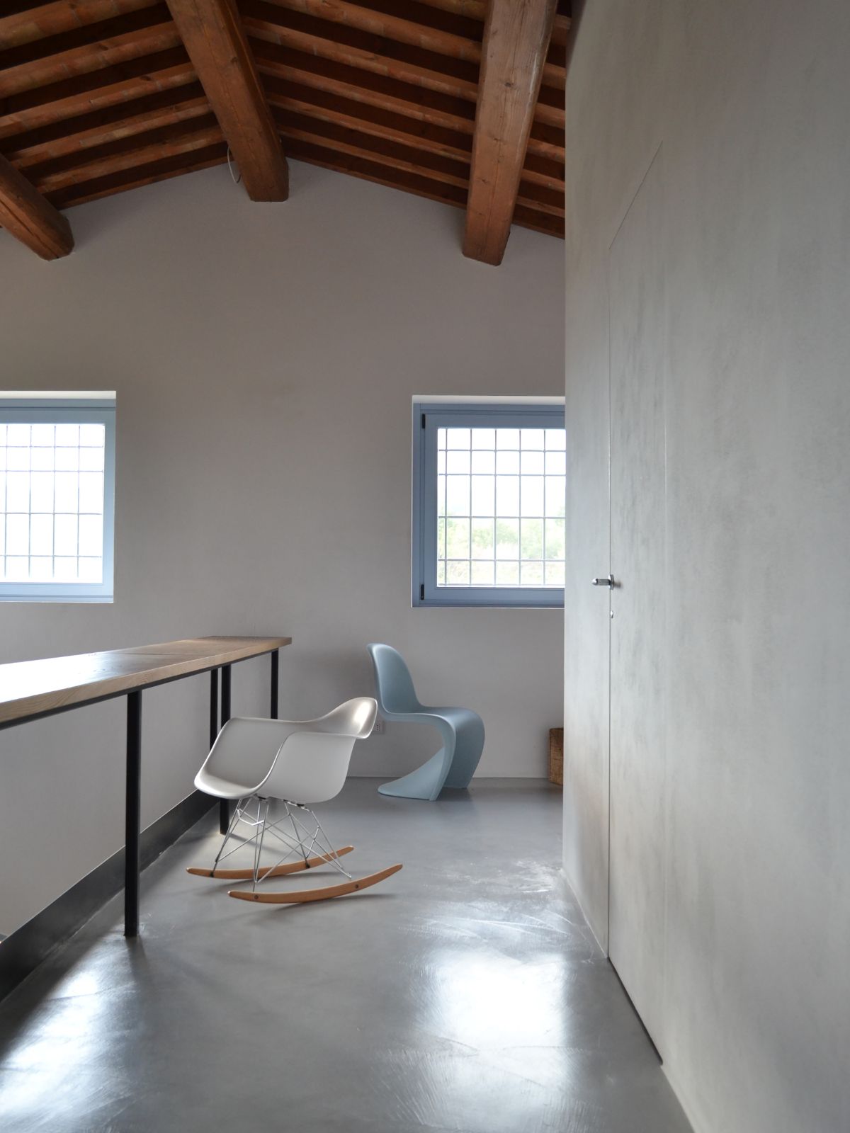 The upper floors feature exposed concrete floors and a rocking chair.