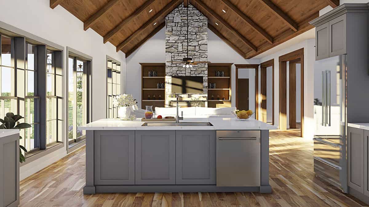 A cathedral ceiling clad in wood planks crowns the open kitchen and living room.