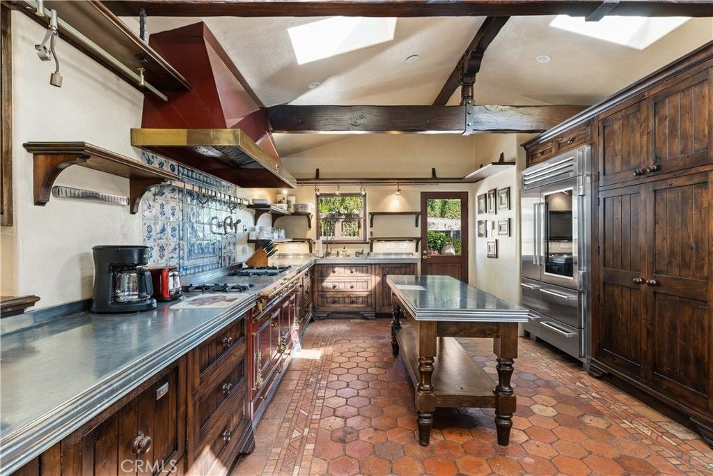 The kitchen features a kitchen island, and the wooden cabinet blends well with the tile flooring giving off a rustic look.