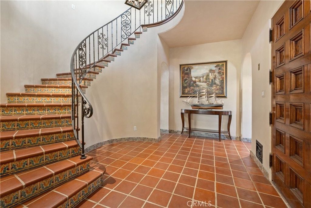 The house features a spiral staircase and a foyer table that adds a classic feel to the room.