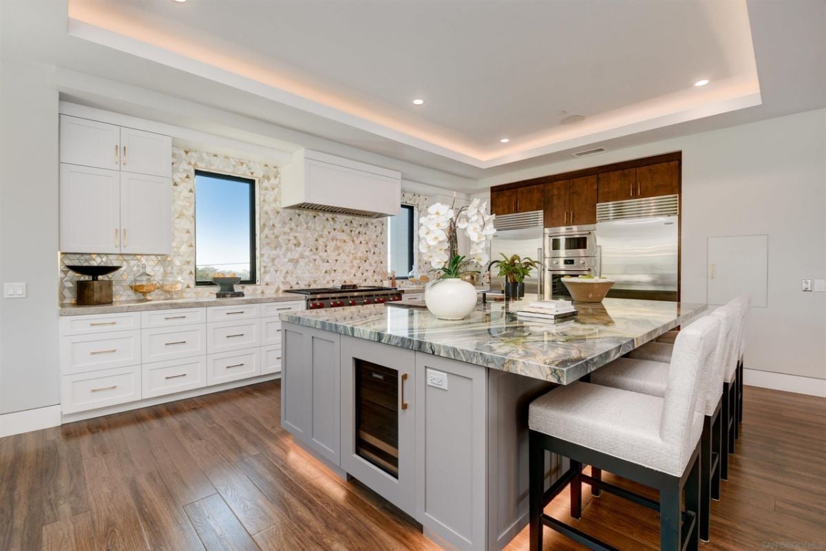 The kitchen features a bi-level kitchen island with a thick marble countertop.