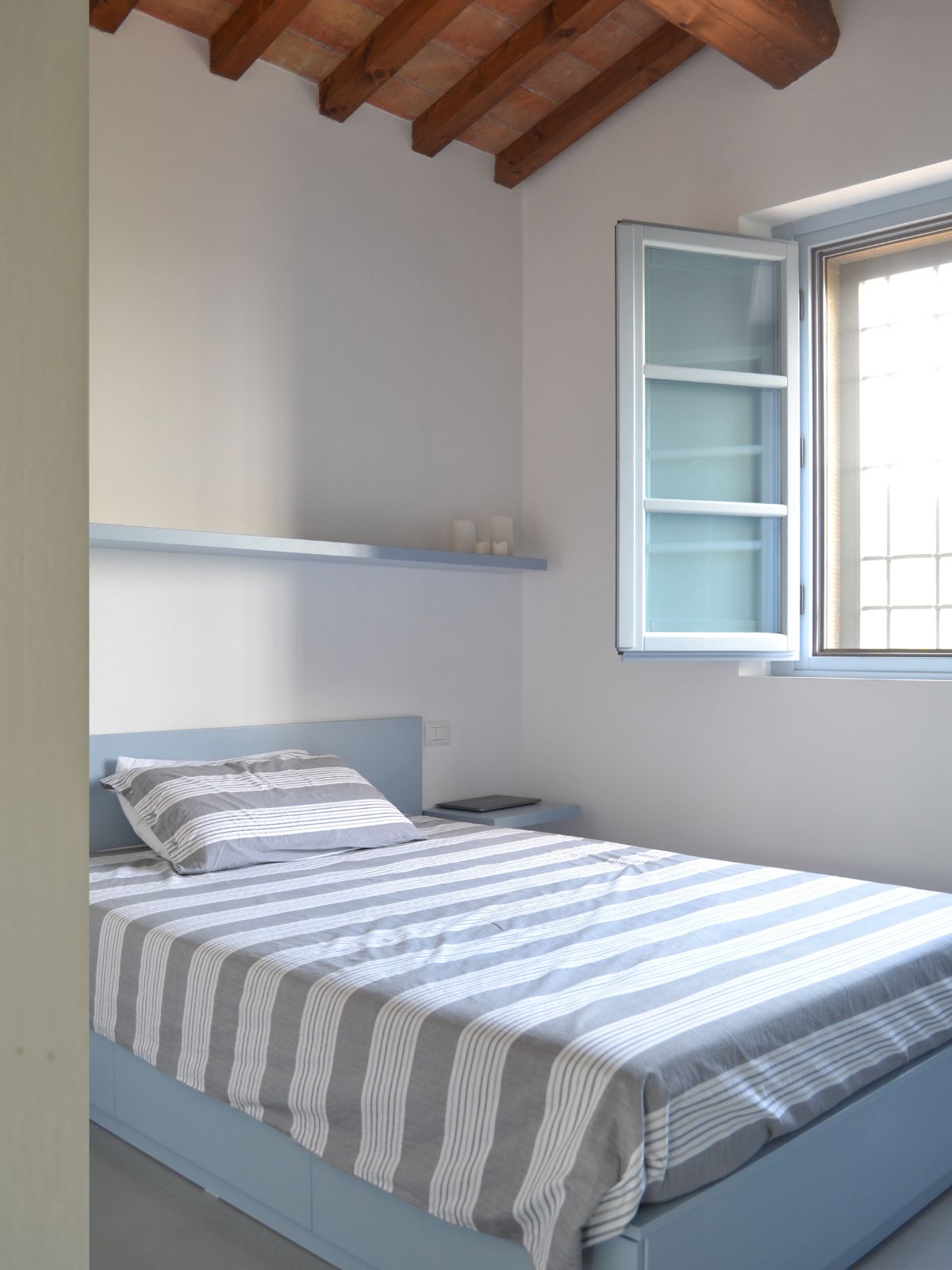 The bedroom features an exposed wooden beam giving the room a cozy feel.