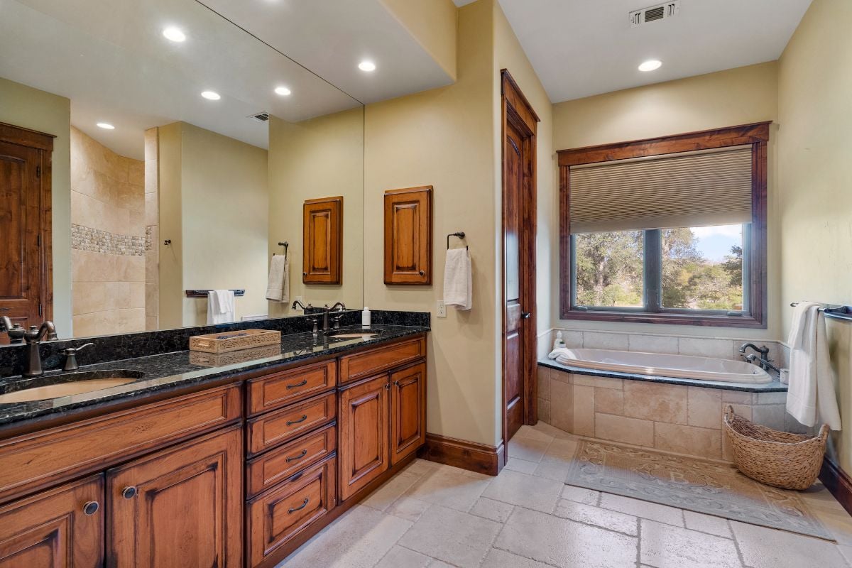 The bathroom features a vanity with a granite countertop and a built-in bathtub.