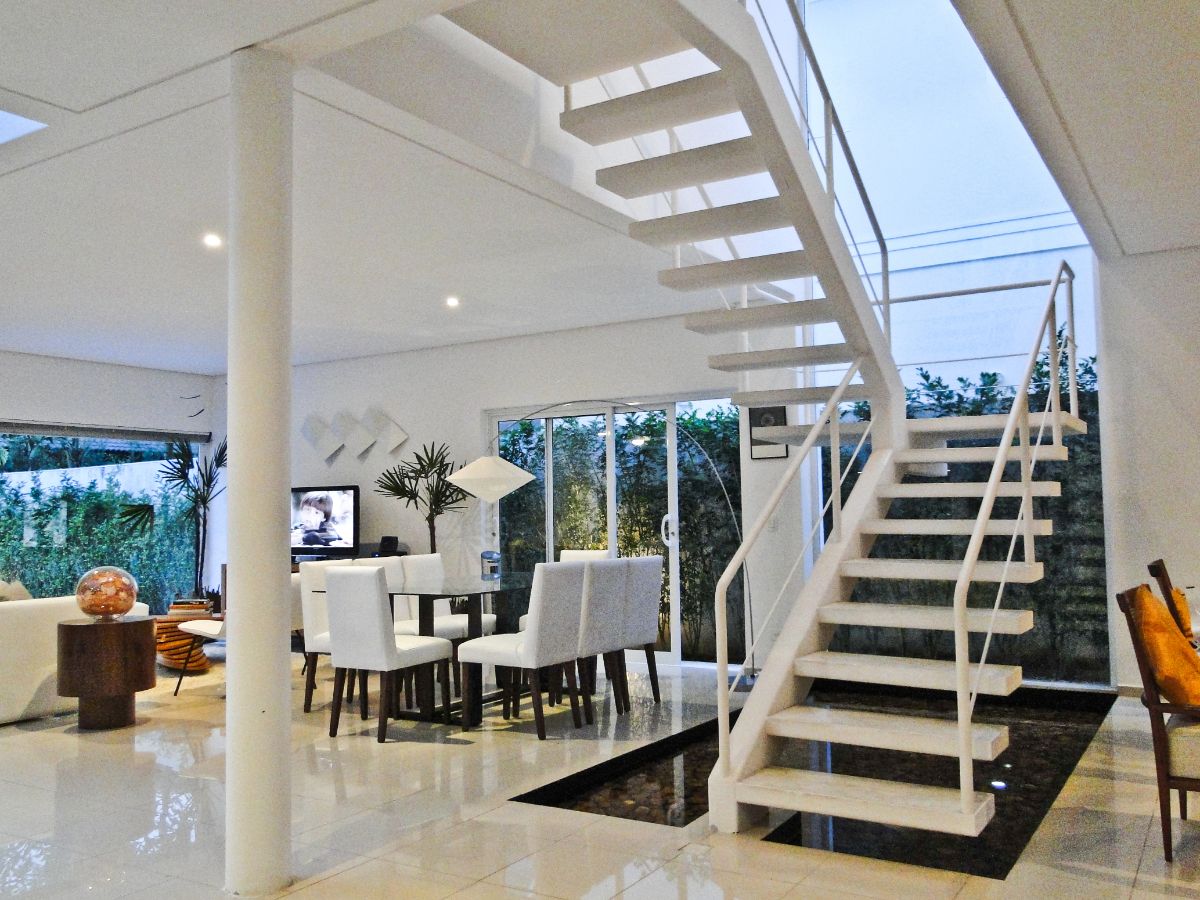 The house features a floating staircase and a small pond below.