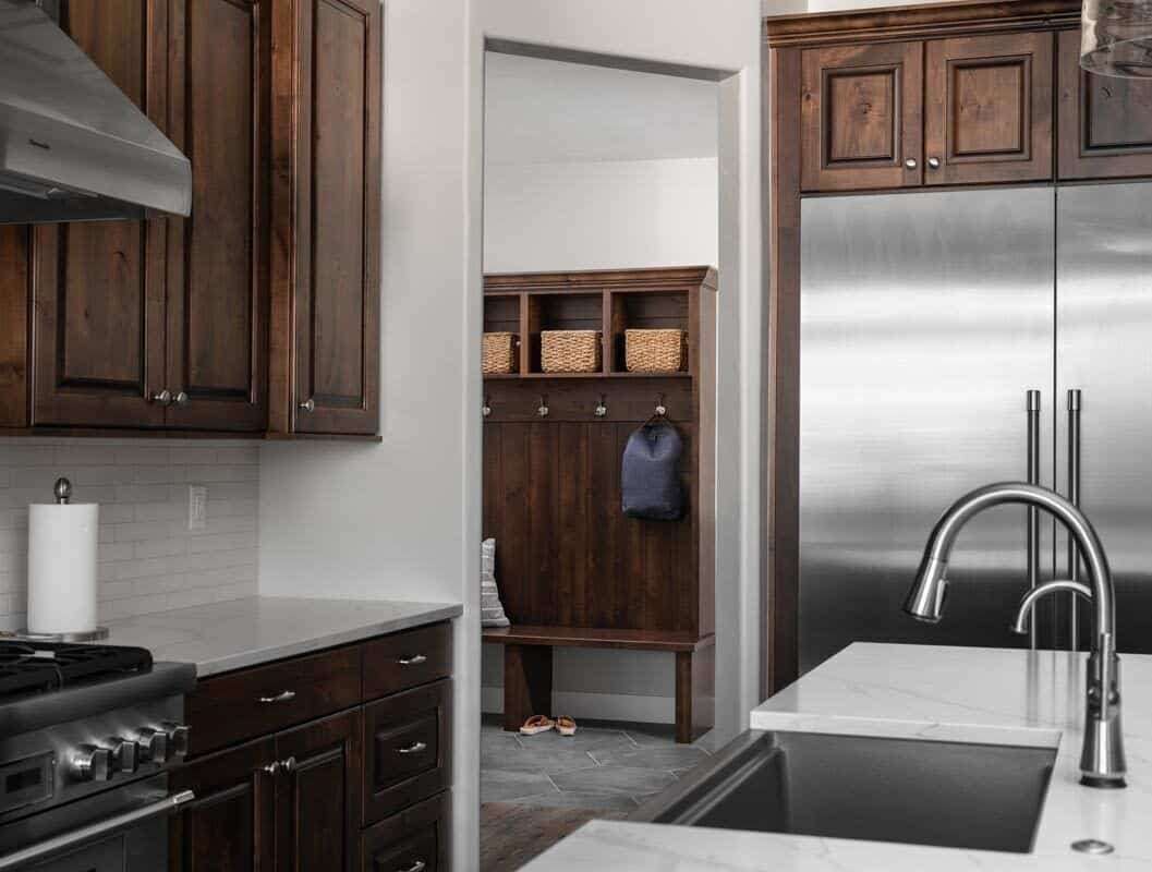 The kitchen has easy access to a mudroom that's equipped with open shelves, coat hooks, and a built-in bench.