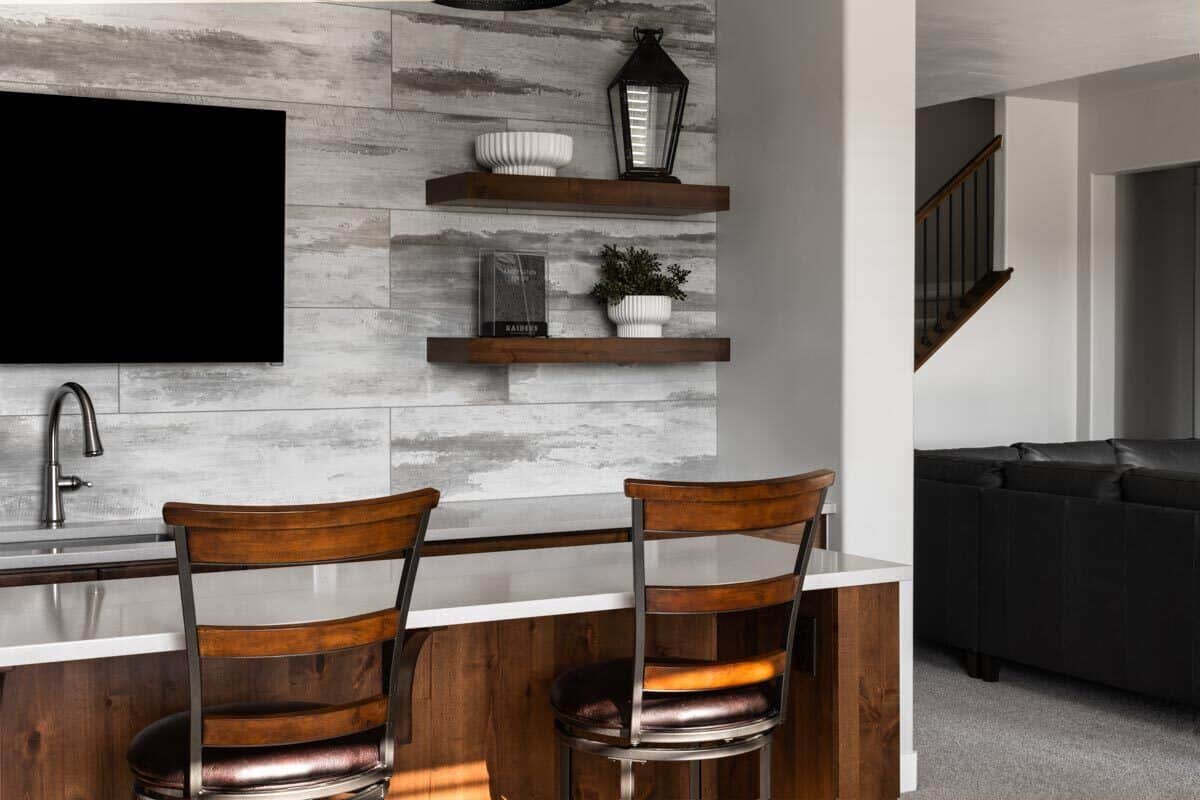 A marble-top island and TV mounted above the sink complete the kitchen.