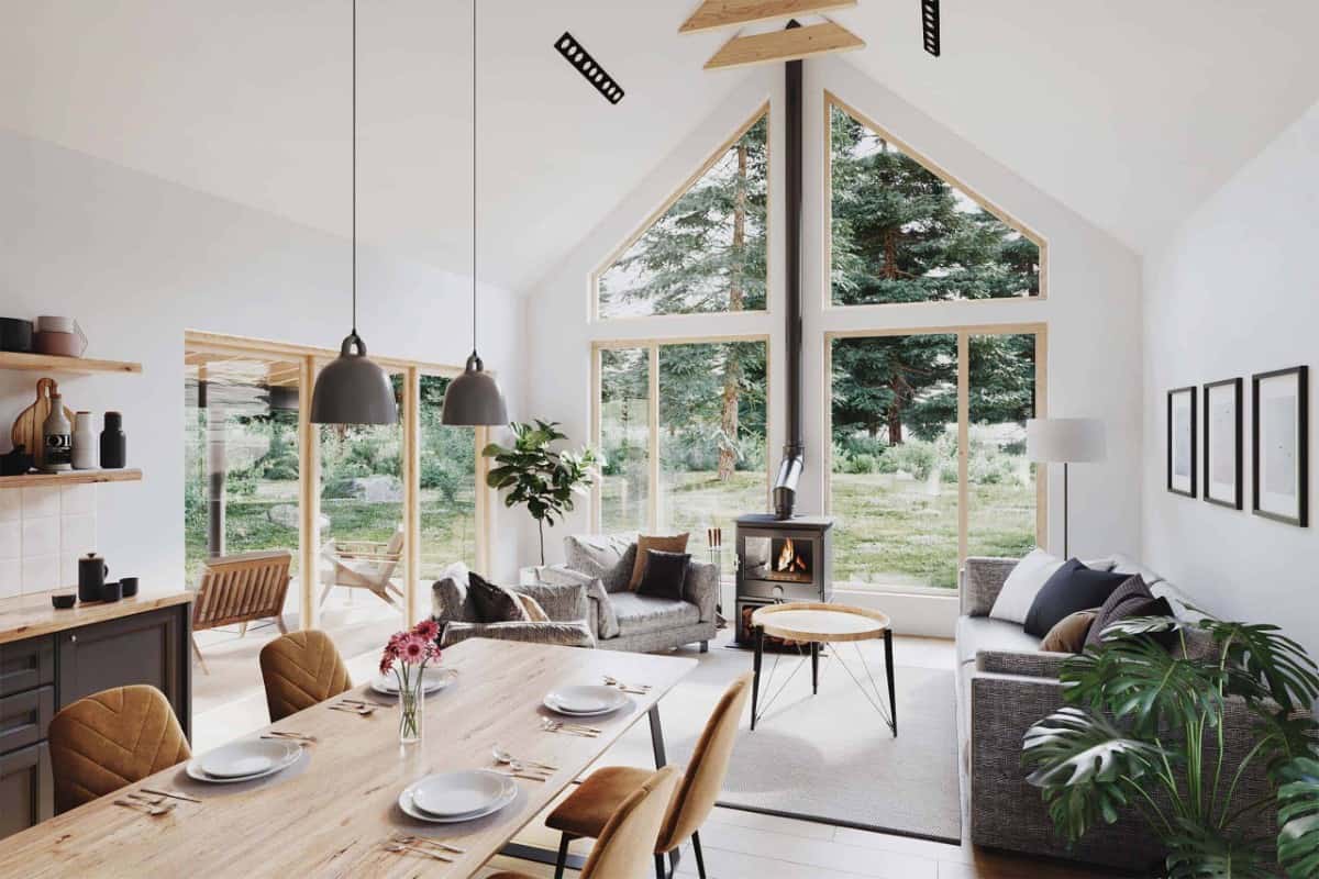 The living area features a wood stove, a cathedral ceiling, and massive windows overlooking the expansive yard.