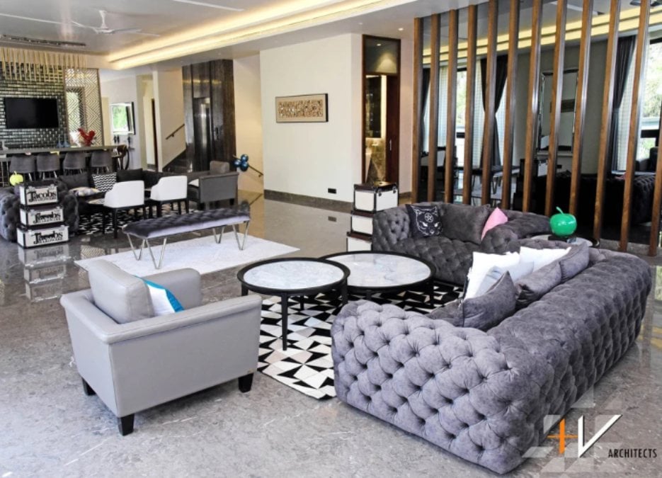 This is an interior shot of a living section filled with various furniture pieces such as sofas, tables, and chairs.
