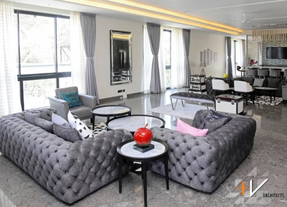 This is an interior shot of a living section filled with various furniture pieces such as sofas, tables, and chairs.