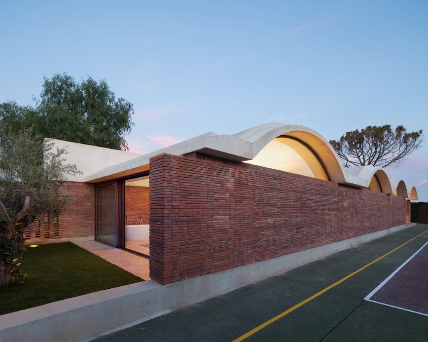 One section of Casa IV reveals the vaulted roof design, with striking red brick wall layers that highlight the building's architectural features.