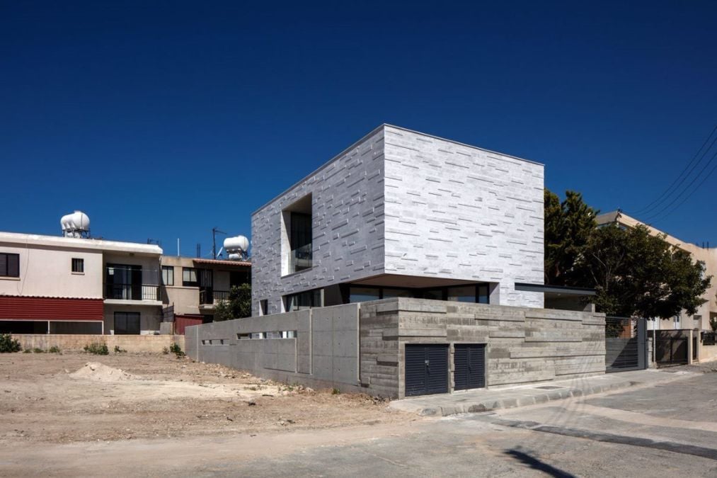 This house is situated on a busy central road and features a marble-clad mass that creates a three-dimensional layout.