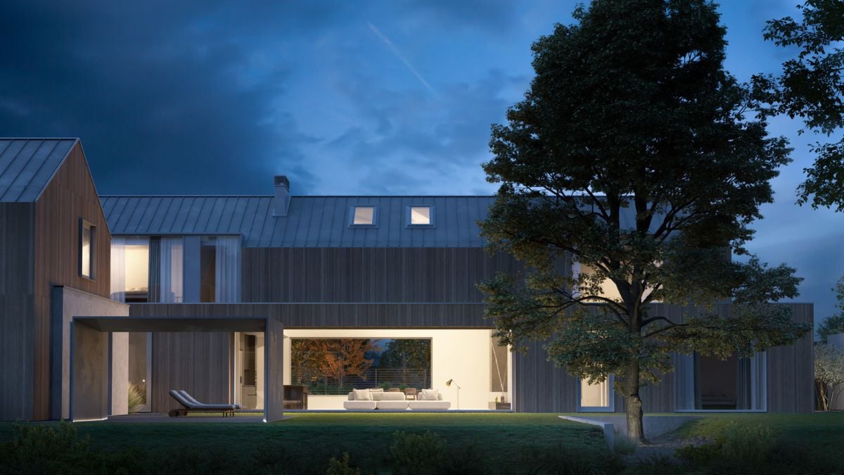 An external view of the house, captured during nighttime, is presented with the silhouette of lush green foliage and a tree in the foreground.