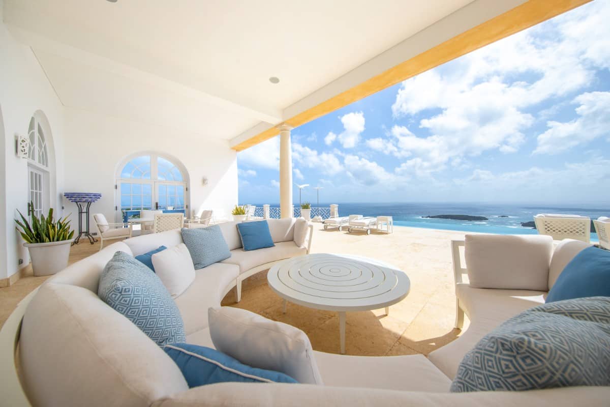 Covered lanai with a curved sectional sofa and unobstructed views of the Atlantic Ocean.