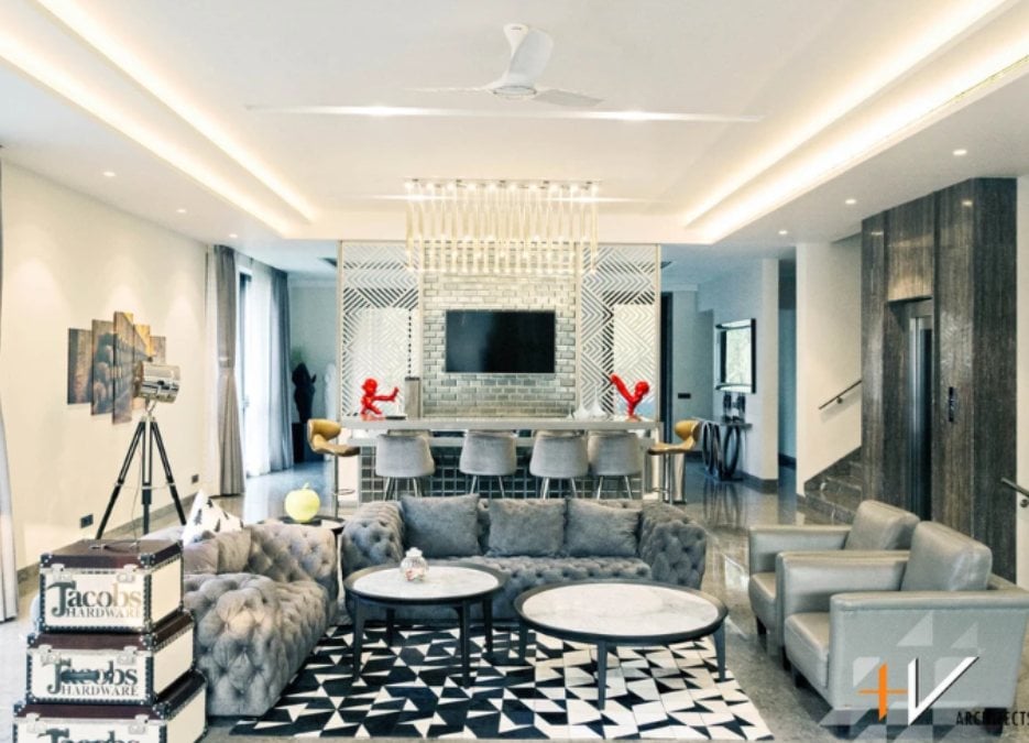 Here is an interior shot of a modern living section filled with furniture and a geometric pattern carpet.