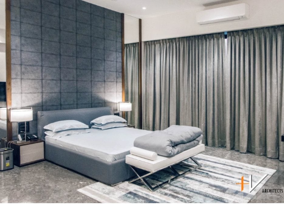 This is a generously sized bedroom that features a gray motif in its design, creating a sophisticated and understated aesthetic.