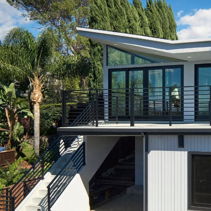 This photograph showcases the exterior architectural design of the house, depicted in a black and white color scheme.