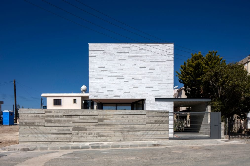 This exterior shot of the house showcases the entire architectural layout, with the fence design prioritizing privacy on the first level.