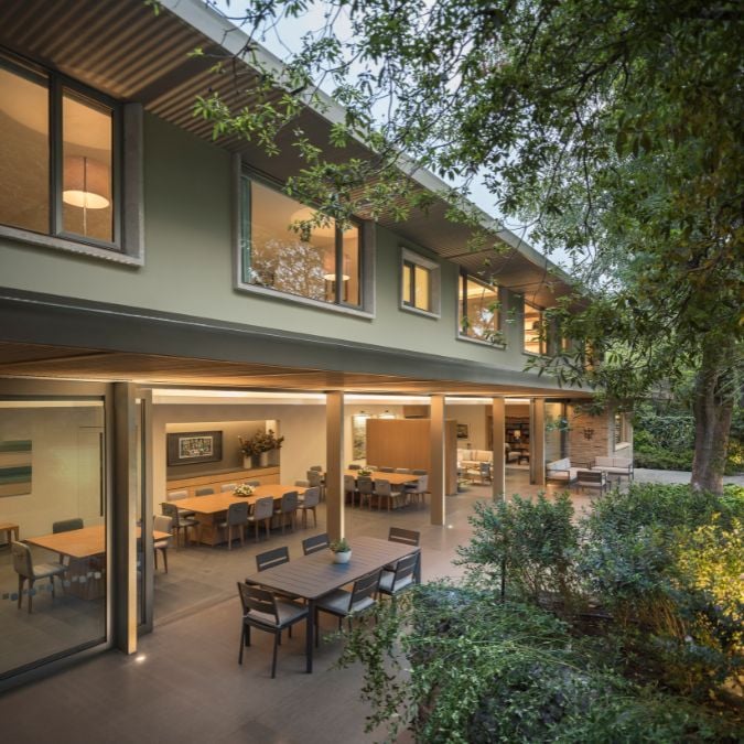 An exterior shot that showcases a patio with a collection of dining sets, as viewed from the stairs located within the courtyard.