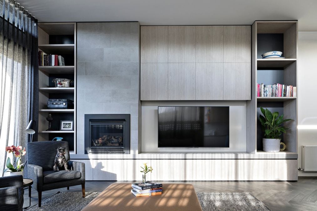 This close-up shot of the living section showcases a beautiful fireplace and a large flat-screen TV prominently featured in the space, complemented by modern furnishings and stylish decor.