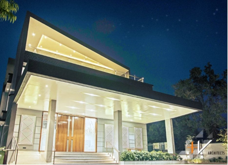 A low angle shot featuring a cantilever roof and a massive entrance door.