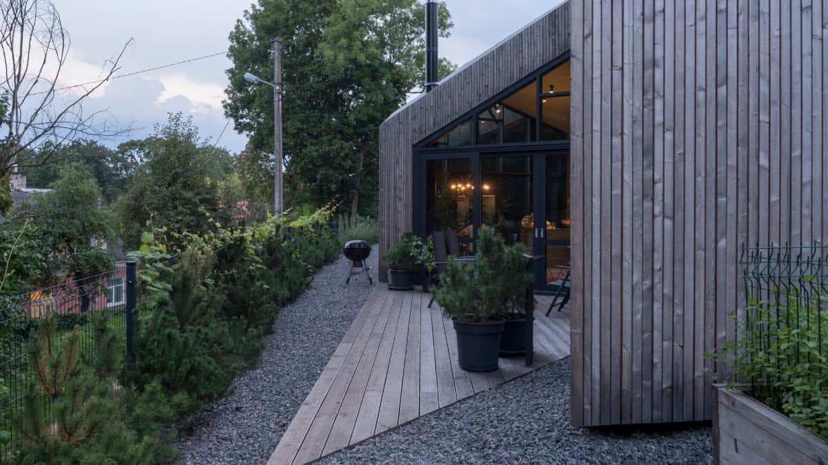 An open patio adorned with potted plants offers a great place to grill.