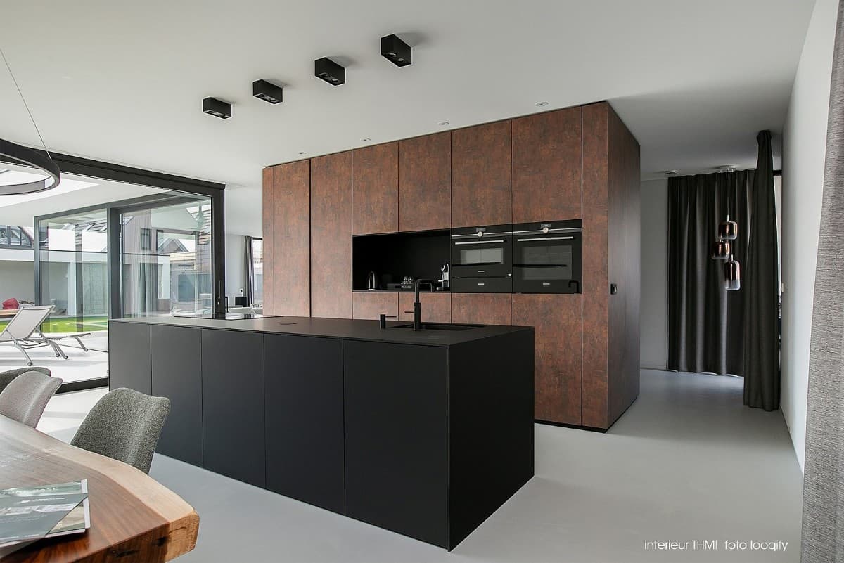 The kitchen's custom cabinetry and black island enhance the home's contemporary appeal.