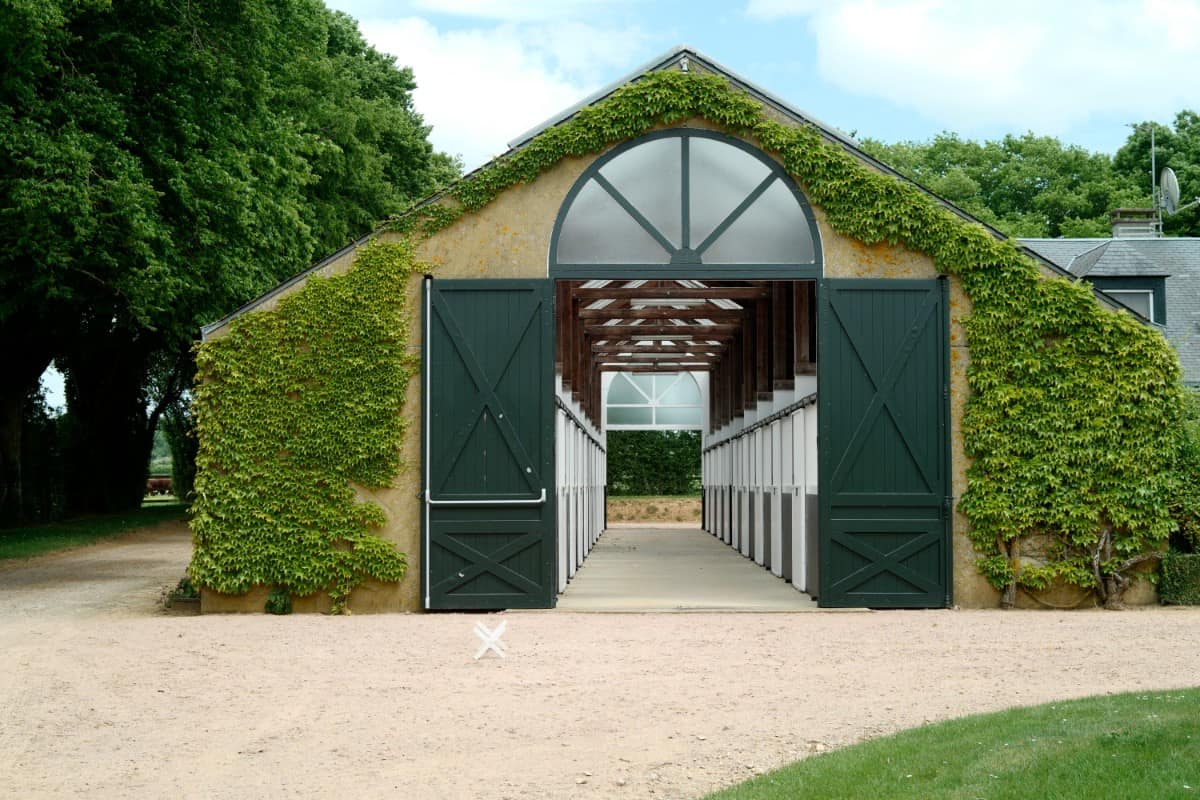 One of the farm's stables is grace with arched transoms and double barn doors.