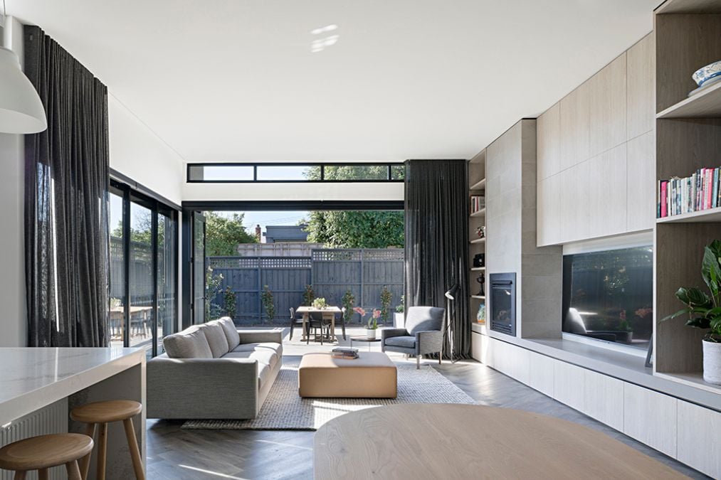 This shot gives a close-up view of the living section, featuring a large flat-screen TV and a cozy fireplace, with modern furnishings and decor that beautifully complement the elegant and spacious design.