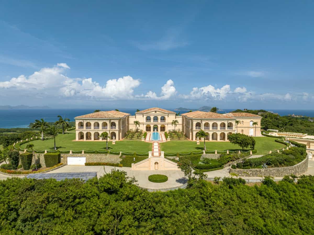 The Caribbean palatial estate includes nine buildings bordered by decorative archways.