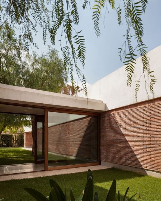 This exterior shot captures the passageway connecting different sections of the building, featuring impressive glass walls that allow for ample natural light and offer a stunning view of the surrounding landscape.